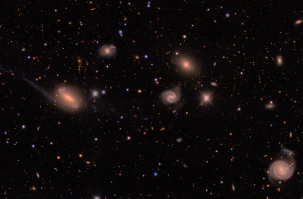 Imatge de DECam d’un camp a la constel·lació austral de Lepus que mostra estrelles de la Via Làctia (petits punts de colors) i un grup de galàxies (els objectes difusos de mida més gran) situat a uns 300 milions d’anys llum. La imatge correspon a una petita fracció d’una de les observacions realitzades amb la Dark Energy Camera. L’anàlisi del DES mesura les galàxies més febles visibles en aquesta imatge. Crèdit: Erin Sheldon i la col·laboració DES