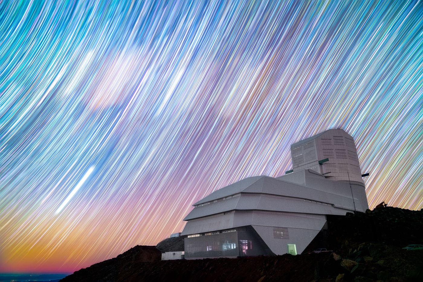 Rubin Observatory stands on Cerro Pachón in Chile against a sky full of star trails in this long exposure night sky image from Rubin staff member Hernán Stockebrand. Credit. Hernan Stockebrand